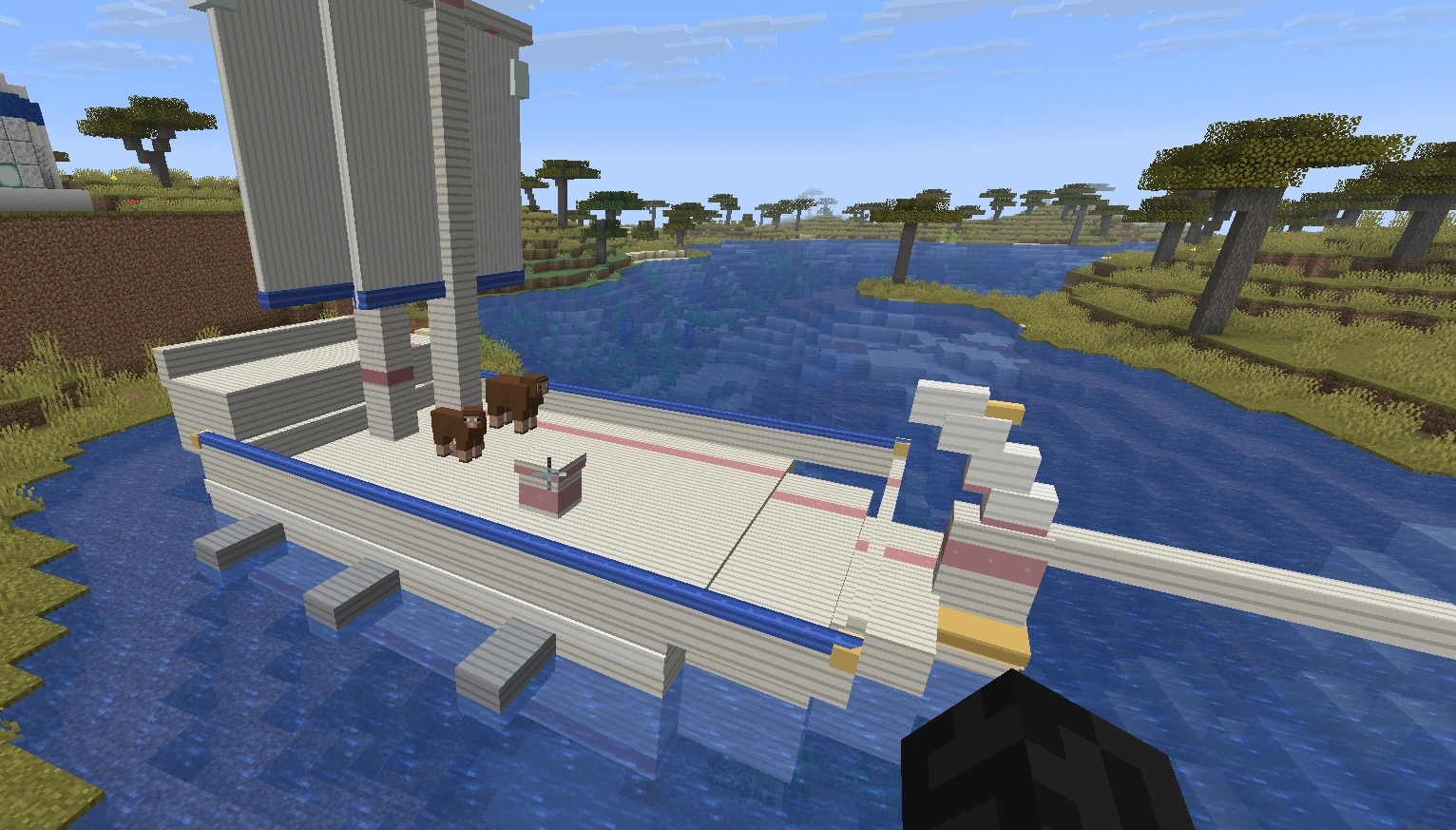 A white and blue elven sailing ship moored on a river, with animals standing on the deck
