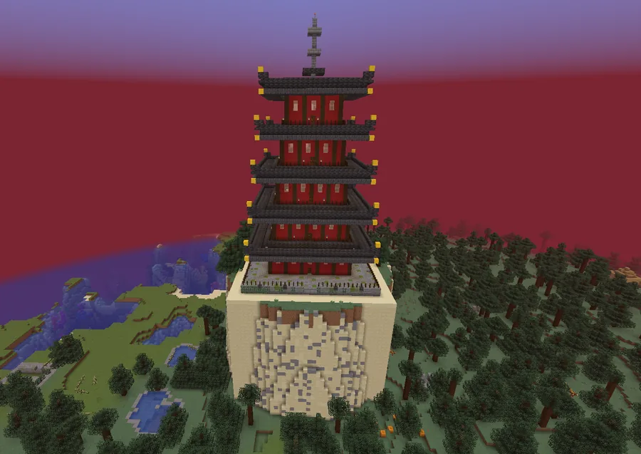 A red five-tiered temple with dark roofs standing on top of a tall stone spire above a forest
